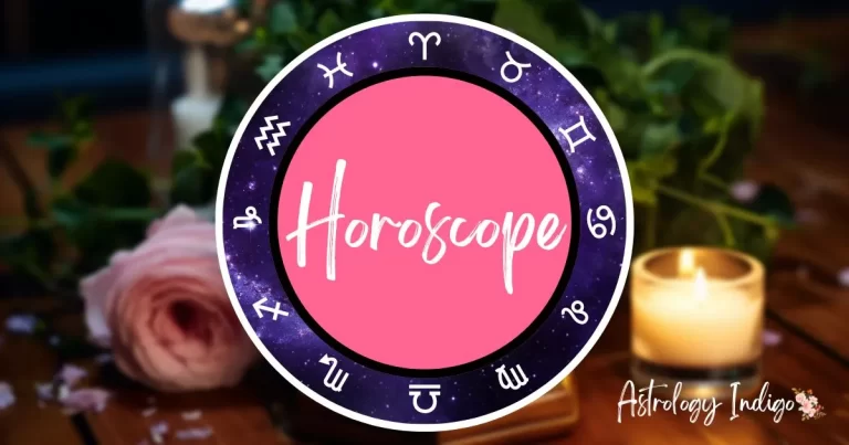 An image of the Zodiac signs in a circle around the word Horoscope sits in front of a desk with flowers and candles